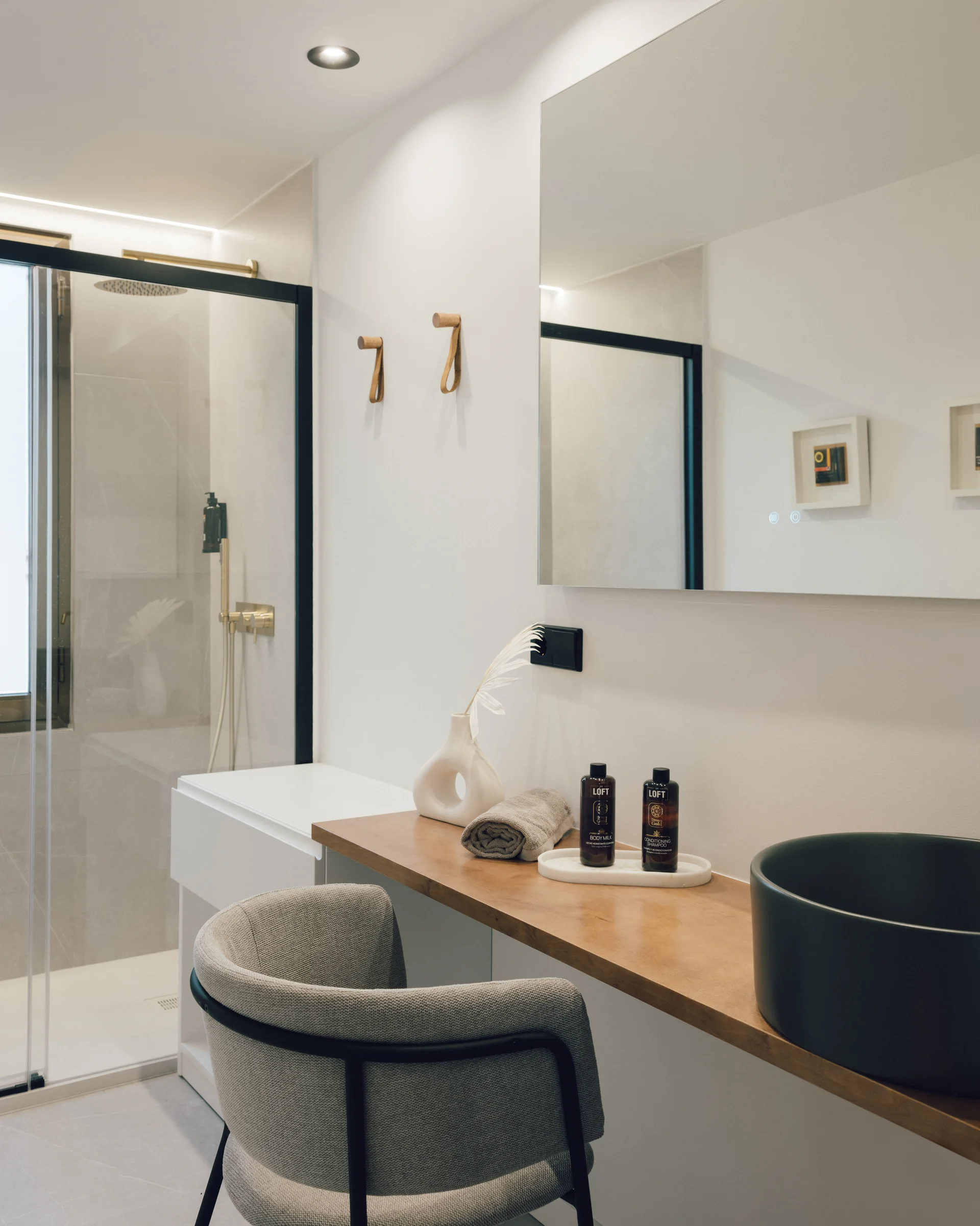 Espacio de ducha y vestuario con lavabo, asiento y toalla en The Loft